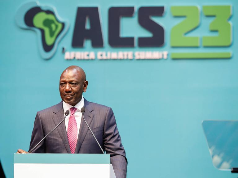Kenias Präsident William Ruto spricht an einem Rednerpult beim Klimagipfel in Nairobi. Hinter ihm an einer Wand der Schriftzug ACS23.