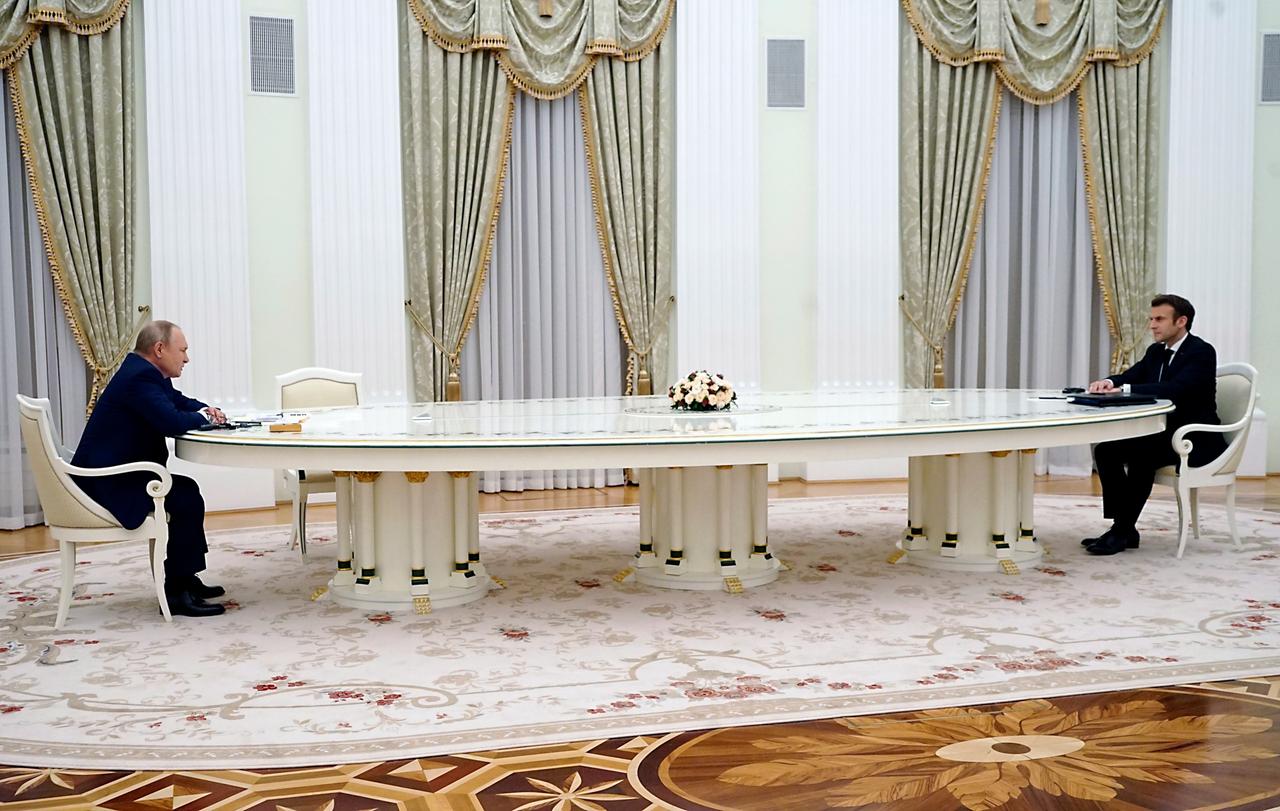 Russlands Präsident Vladimir Putin und Frankreichs Präsident Emanuel Macron sitzen an einem langen weißen Konferenztisch im Kremel