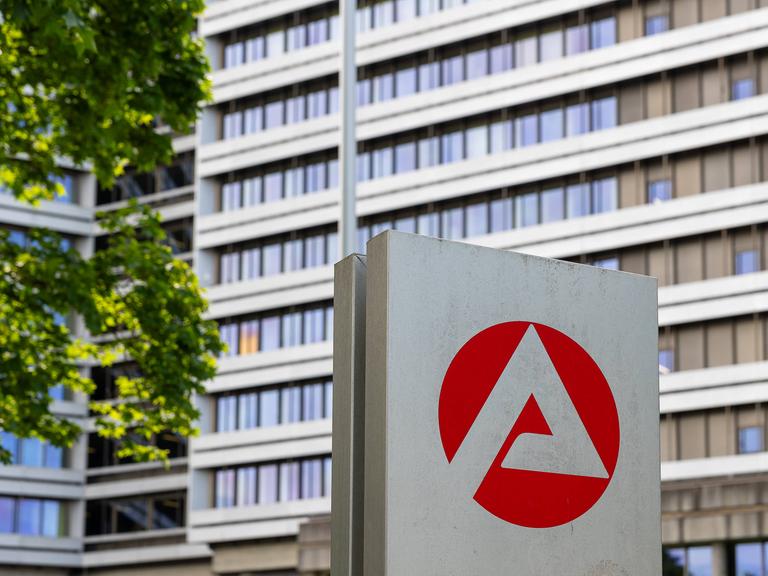 Die Zentrale der Bundesagentur für Arbeit in Arbeit. Vor dem Bürogebäude ist das rot-weiße Logo zu sehen. 