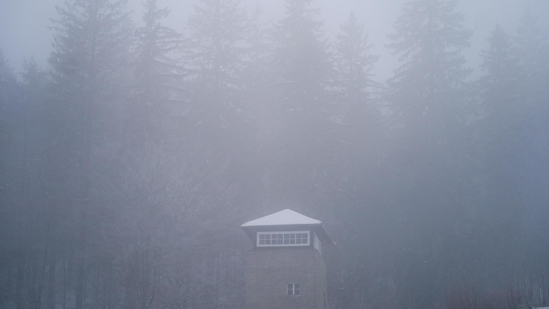 Dichter Nebel hängt über einem Turm innerhalb des KZ Flossenbürg. 