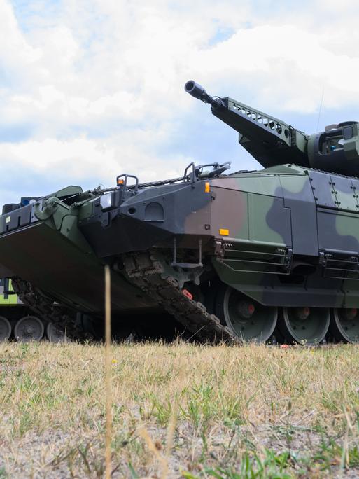 Ein "Infanterist der Zukunft" steht neben einem Schützenpanzer "Puma" des Rüstungskonzerns Rheinmetall 