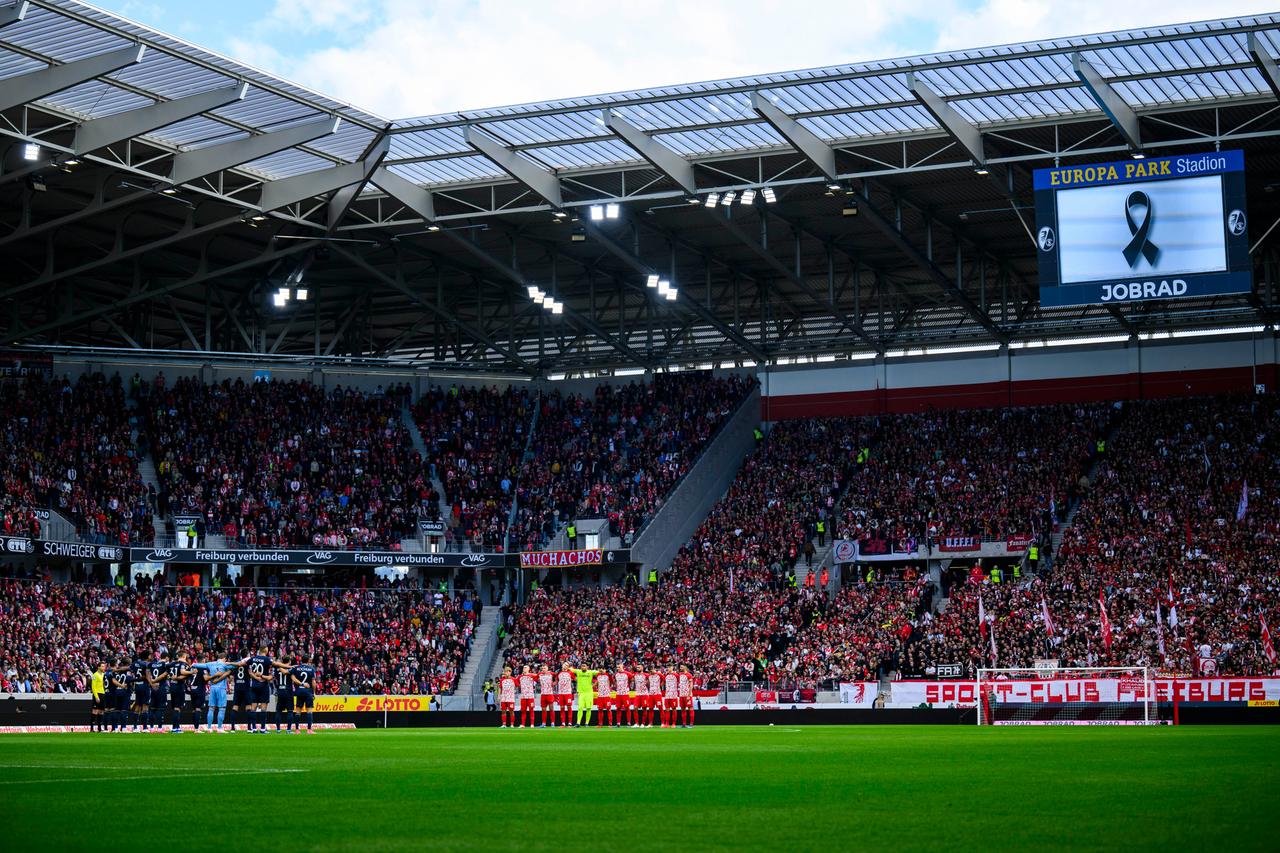 Bei der Bundesliga-Partie Freiburg - Bochum stehen die Spieler im Stadion bei einer Schweigeminute vor dem Spiel zusammen. 