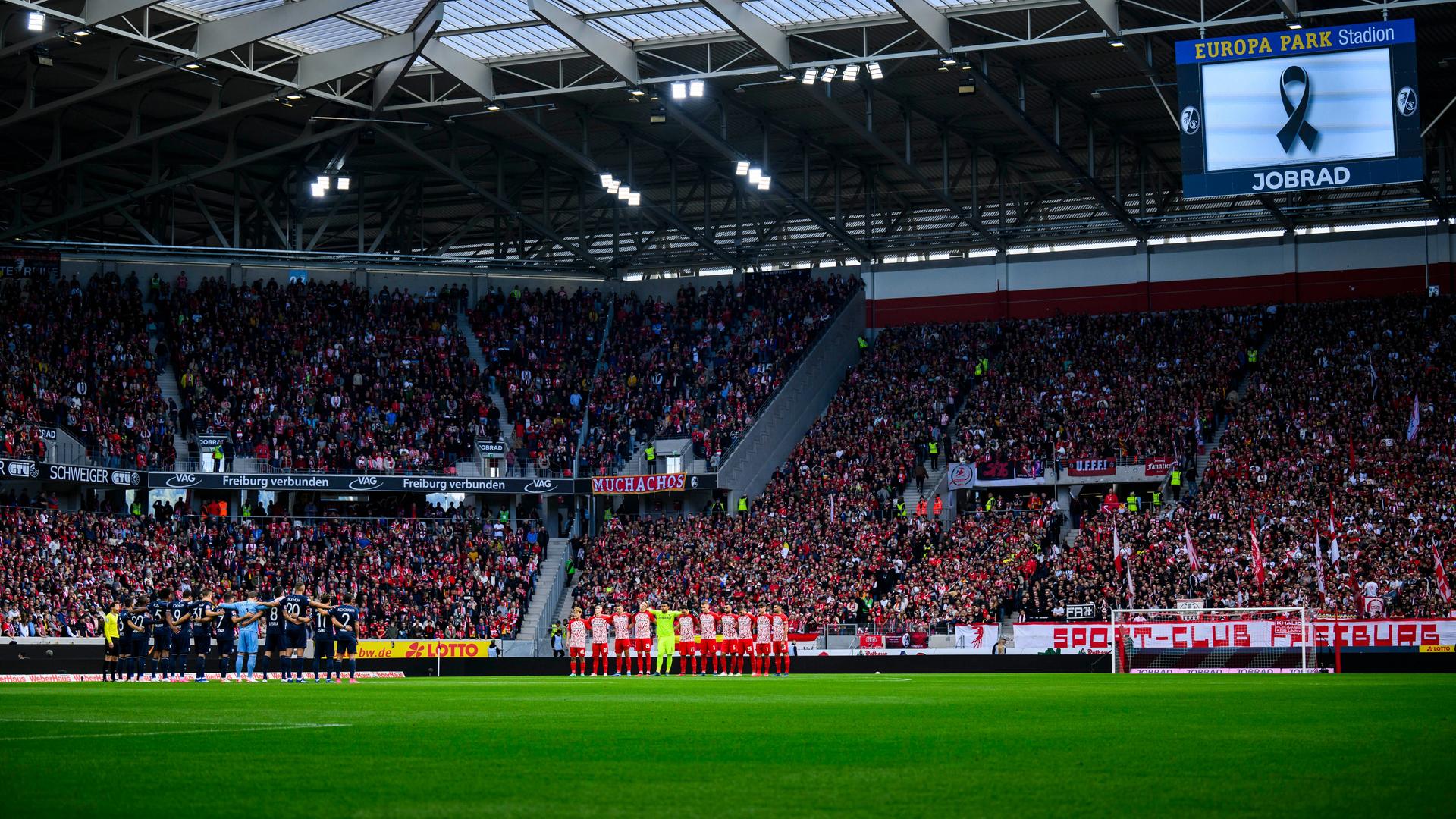 Bei der Bundesliga-Partie Freiburg - Bochum stehen die Spieler im Stadion bei einer Schweigeminute vor dem Spiel zusammen. Bei der Bundesliga-Partie Freiburg - Bochum stehen die Spieler im Stadion bei einer Schweigeminute vor dem Spiel zusammen.