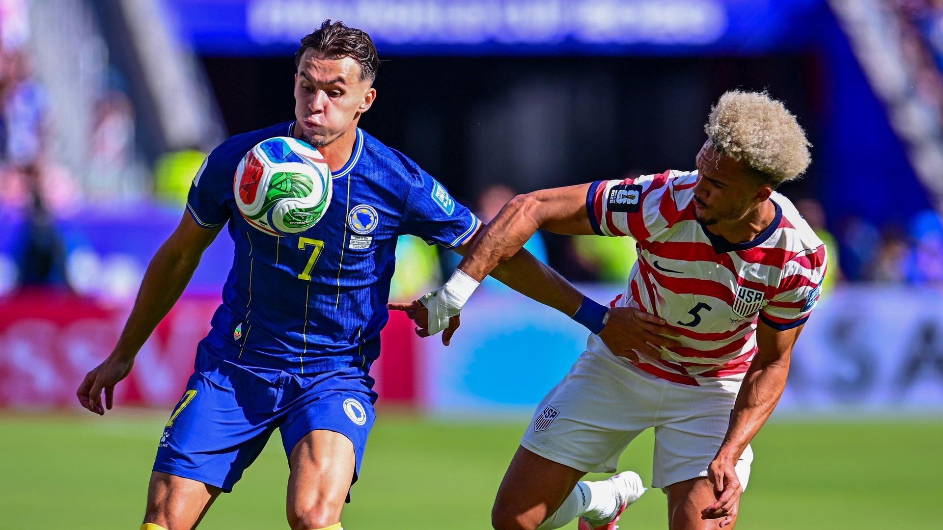 FIFA WM 2026: Amar Dedic (l) aus Bosnien Herzegowina in Aktion mit Antonee Robinson aus den USA. FIFA WM 2026: Amar Dedic (l) aus Bosnien Herzegowina in Aktion mit Antonee Robinson aus den USA.