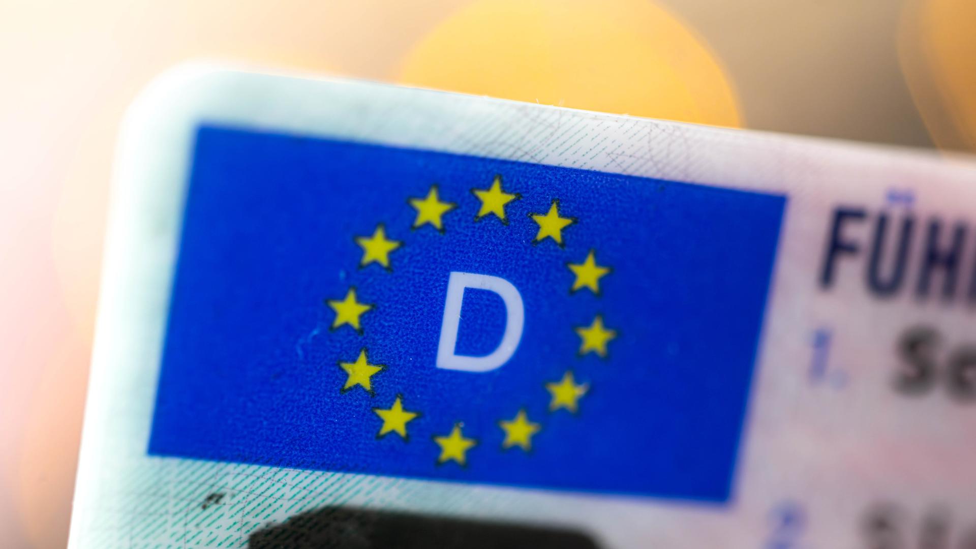 Linke obere Ecke eines deutschen Führerscheins ist mit der Europa-Flagge zu sehen - zwölf goldene Sterne auf blauem Hintergrund. Linke obere Ecke eines deutschen Führerscheins ist mit der Europa-Flagge zu sehen - zwölf goldene Sterne auf blauem Hintergrund.
