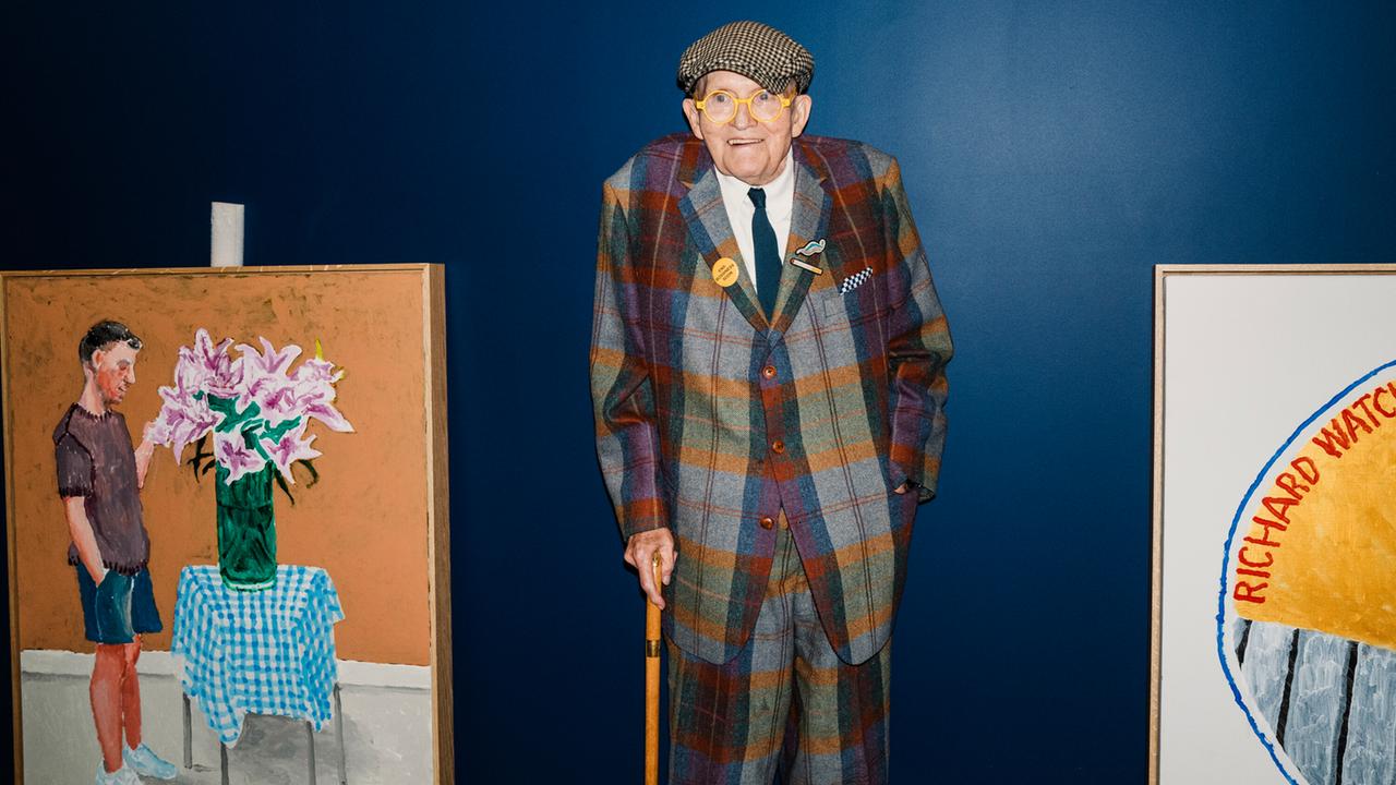 David Hockney bei seiner letzten Ausstellung im Annely Juda Fine Art in Hanover Square in London. Er steht, auf den Stock gestützt, zwischen zwei seiner Bilder.