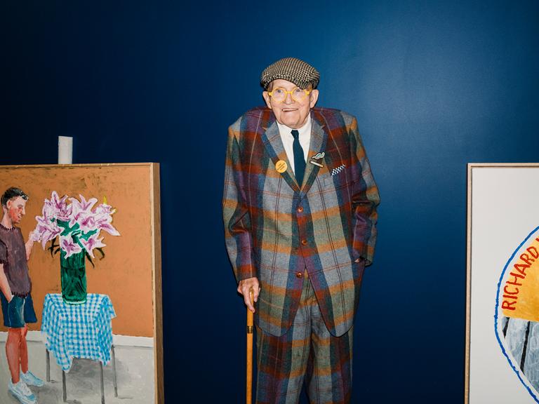 David Hockney bei seiner letzten Ausstellung im Annely Juda Fine Art in Hanover Square in London. Er steht, auf den Stock gestützt, zwischen zwei seiner Bilder.