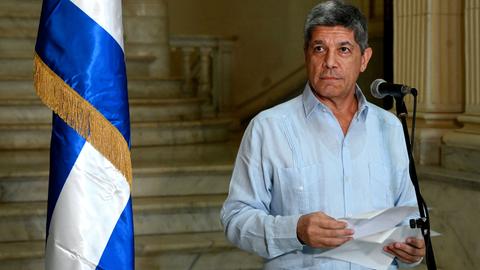 Der stellvertretende kubanische Außenminister Carlos Fernandez de Cossio steht hinter einem Mikrofon. Neben ihm ist eine kubanische Flagge.