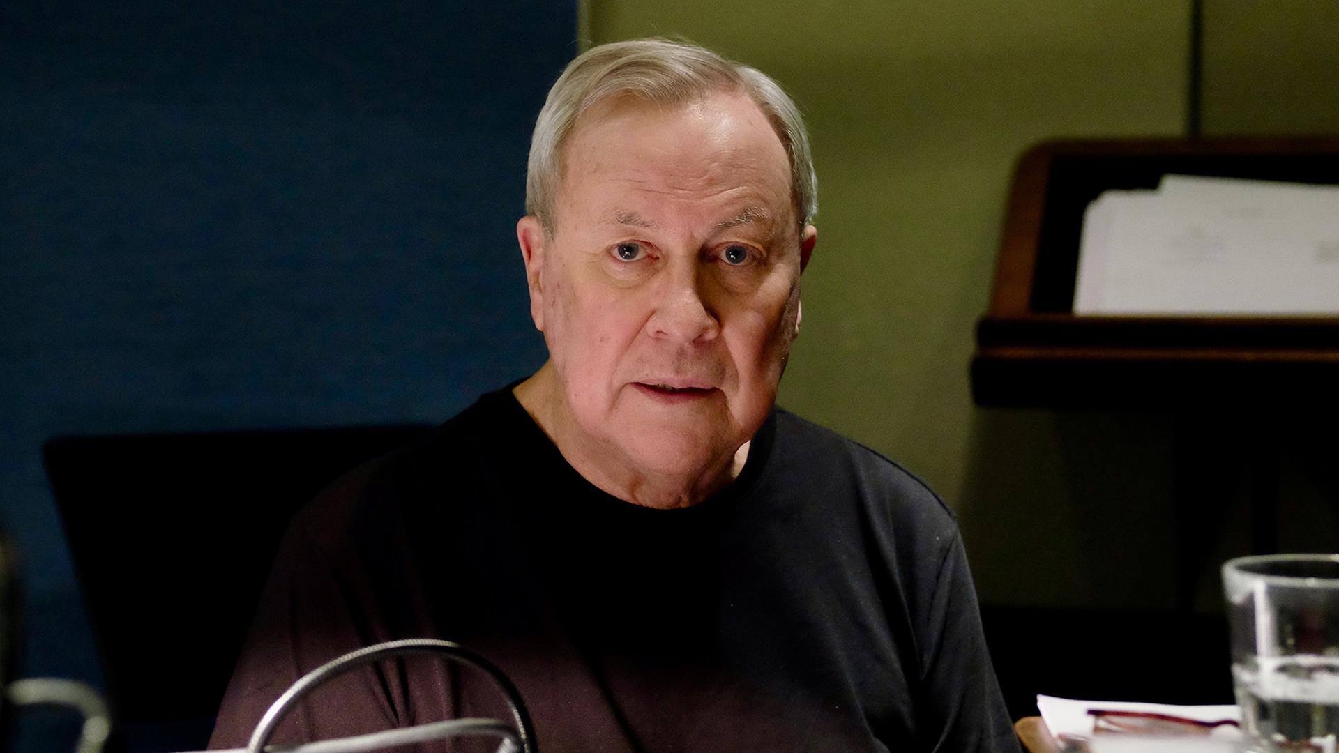 Robert Wilson sitzt im Hörspielstudio und schaut in die Kamera