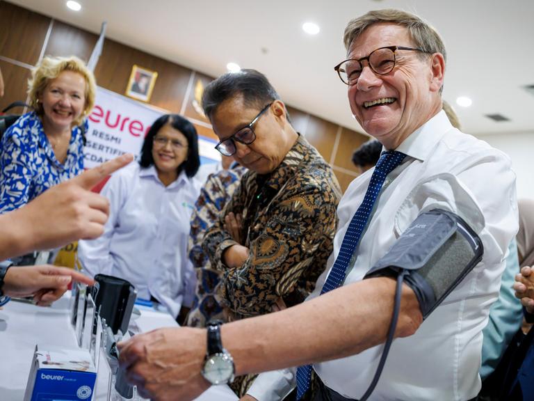 Bundesaußenminister Johann Wadephul (CDU) lässt sich den Puls messen und lacht dabei: Bei einem Besuch der staatlichen Fachhochschule für Gesundheitsberufe in Jakarta, Indonesien.