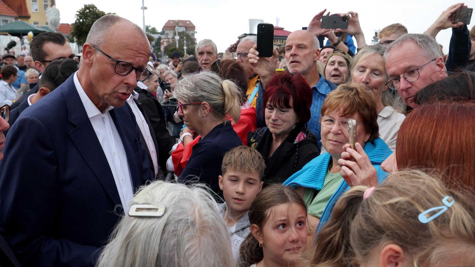 Bundeskanzler Friedrich Merz (CDU, l) spricht bei einer Wahlkampfveranstaltung der CDU mit Menschen. Bundeskanzler Friedrich Merz (CDU, l) spricht bei einer Wahlkampfveranstaltung der CDU mit Menschen.