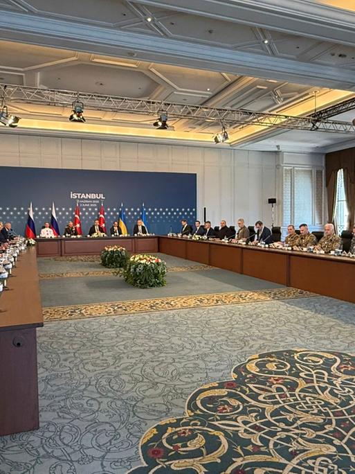 Vertreter von Russland und der Ukraine sitzen in einem Gebäude in  der Stadt  Istanbul in dem Land Türkei an einem großen Tisch.
