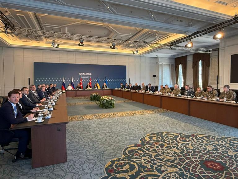 Vertreter von Russland und der Ukraine sitzen in einem Gebäude in  der Stadt  Istanbul in dem Land Türkei an einem großen Tisch.
