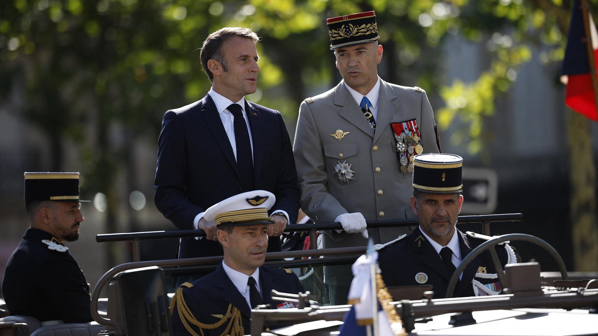 Frankreichs Präsident Emmanuel Macron (oben links) neben Militärs in einem Fahrzeug der Armee. 