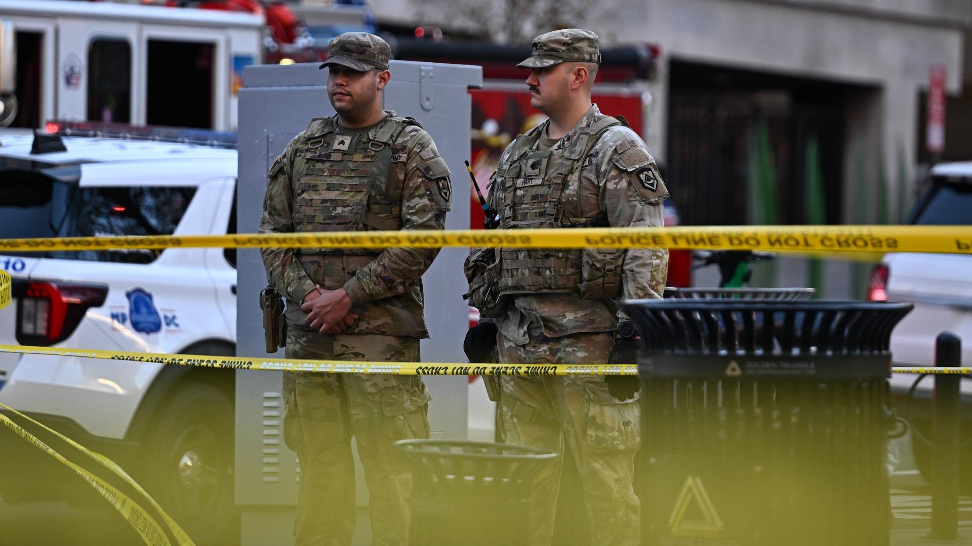 Zwei Nationalgardisten stehen hinter gelbem Flatterband.