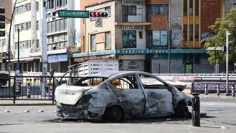 Ein ausgebranntes Auto steht auf einer Straßenkreuzung in Guadalajara. Ein ausgebranntes Auto steht auf einer Straßenkreuzung in Guadalajara.