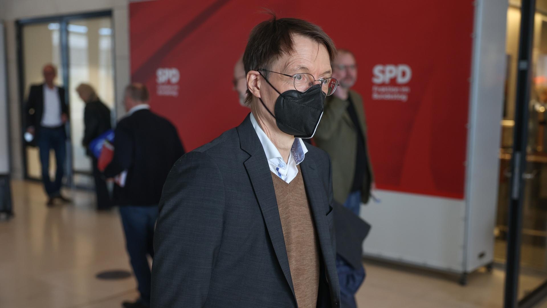 Bundesgesundheitsminister Karl Lauterbach (SPD) geht mit Maske durch den Raum 