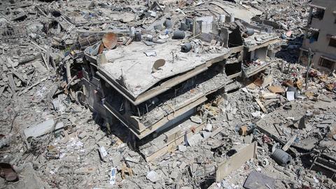 Ein fast vollkommen zerstörtes Gebäude steht in einer Trümmerlandschaft im Gazastreifen.