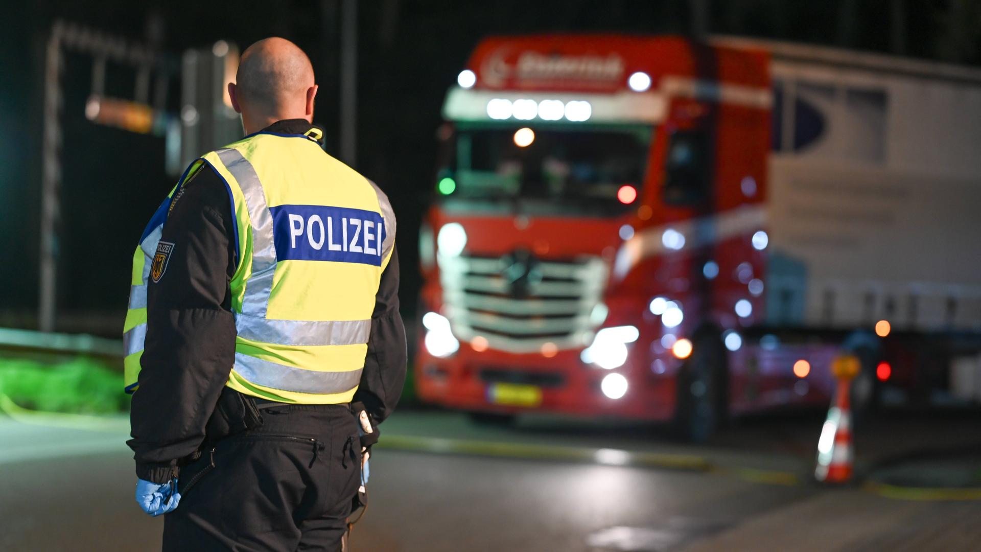 Grenzkontrolle in Bad Bentheim: Im Vordergrund ein Bundespolizist, im Hintergrund ein Lkw.