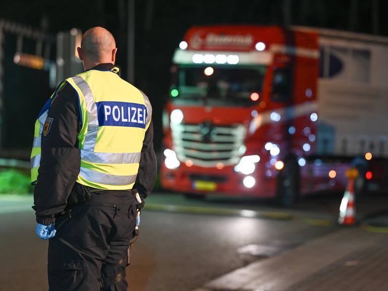 Grenzkontrolle in Bad Bentheim: Im Vordergrund ein Bundespolizist, im Hintergrund ein Lkw.