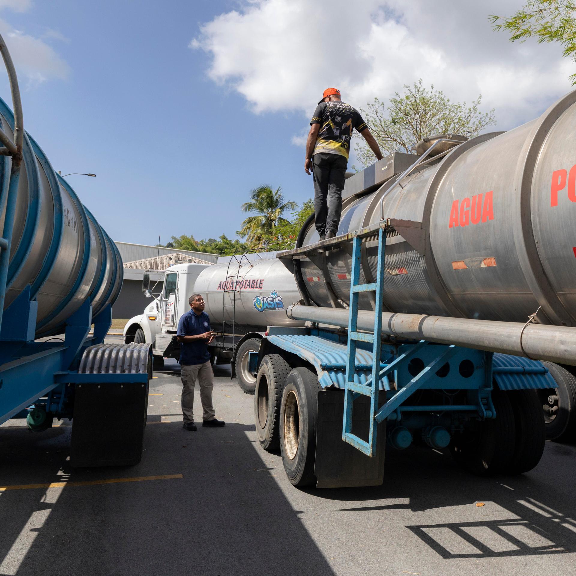 Ein Arbeiter läuft auf einem mit der Aufschrift "Agua Potable" versehenen Wassertankwagen im Rahmen einer Wasserverteilungsaktion in Puerto Rico am 17. Juli 2026. (Foto: Alejandro Granadillo/NurPhoto)