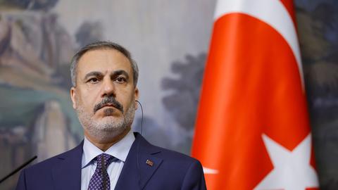 Der türkische Außenminister Fidan nimmt an einer Pressekonferenz teil und steht vor der türkischen Nationalflagge.
