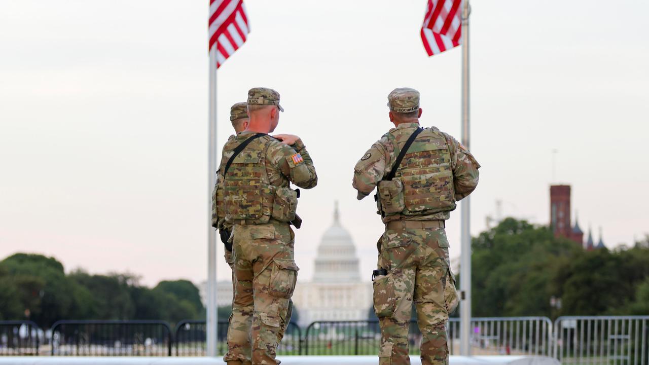 Zwei Soldaten der US National Guard stehen in Washington unter zwei US-Flaggen
