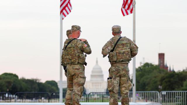 Zwei Soldaten der US National Guard stehen in Washington unter zwei US-Flaggen