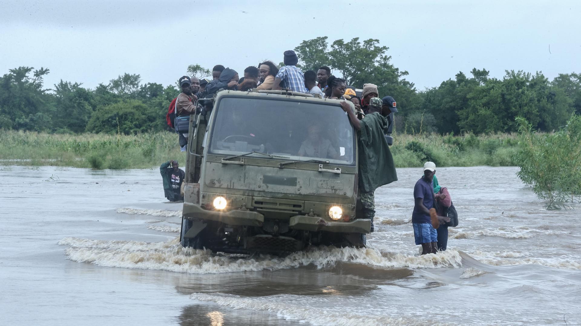 Anwohner werden mit einem Militärlastwagen durch das Hochwasser gebracht, das eine Straße überschwemmt hat. 