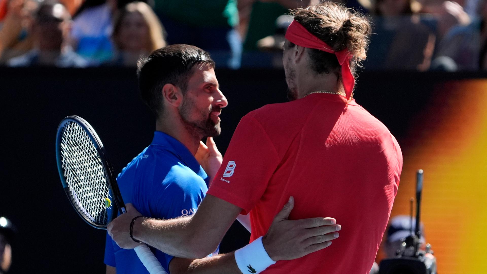 Alexander Zverev (rechts) und Novak Djokovic umarmen sich nach dem Spiel.