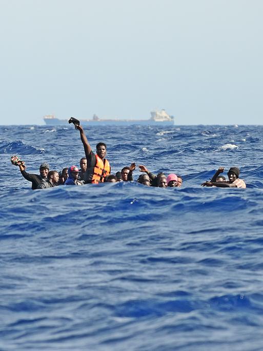 Migration über das Mittelmeer: Ein Holzboot mit etwa 30 Menschen an Bord ist bei hohen Wellengang in Seenot geraten. Die Männer rufen um Hilfe.