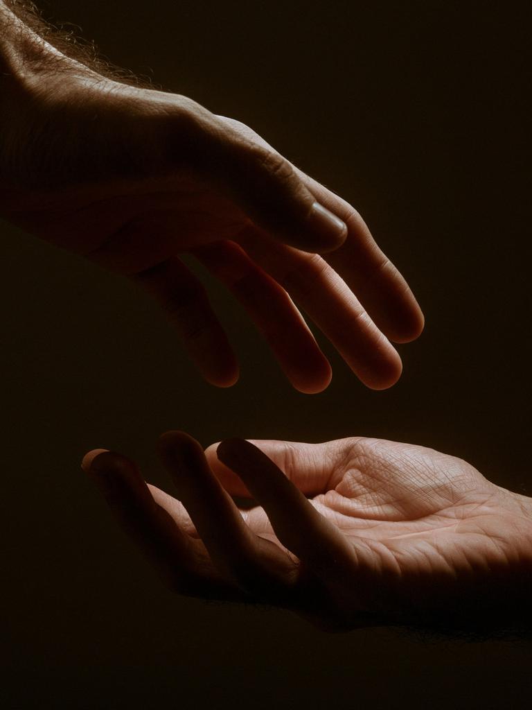 Zwei Hände vor schwarzem Hintergrund