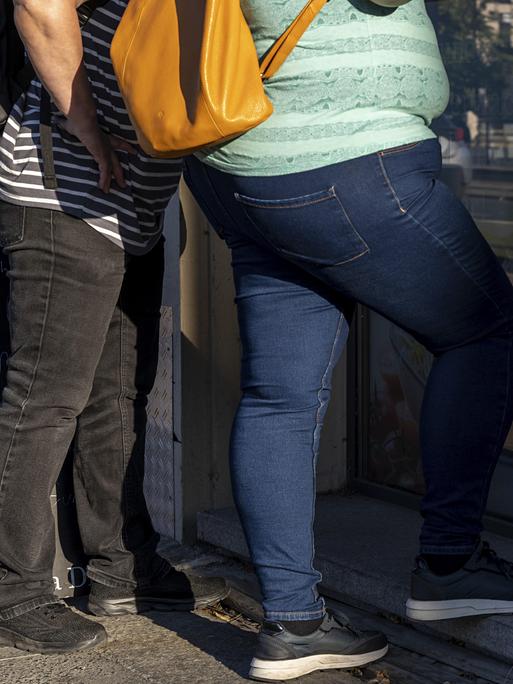 Personen mit Adipositas stehen an einer Eisdiele Personen mit Adipositas stehen an einer Eisdiele