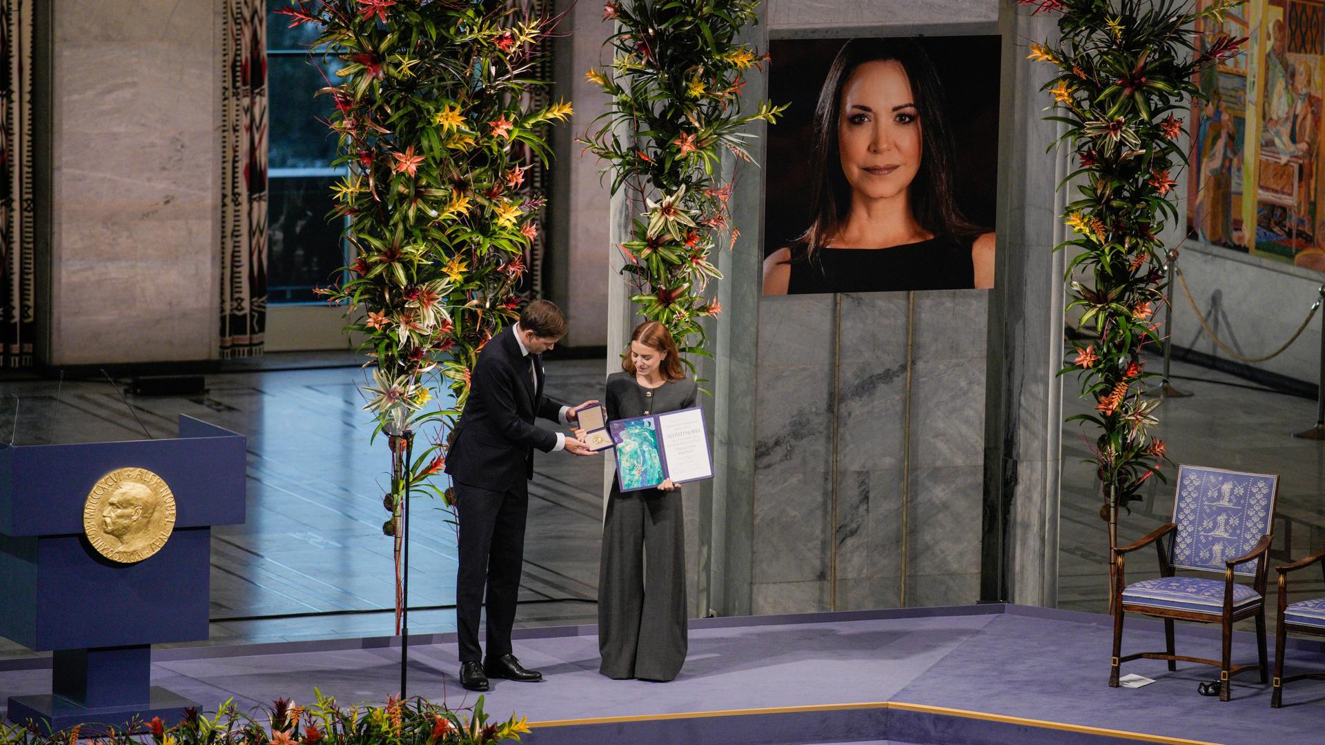 Ana Corina Sosa, die Tochter der Friedensnobelpreisträgerin Maria Corina Machado, nimmt die Auszeichnung stellvertretend für ihre Mutter entgegen. Ana Corina Sosa, die Tochter der Friedensnobelpreisträgerin Maria Corina Machado, nimmt die Auszeichnung stellvertretend für ihre Mutter entgegen.