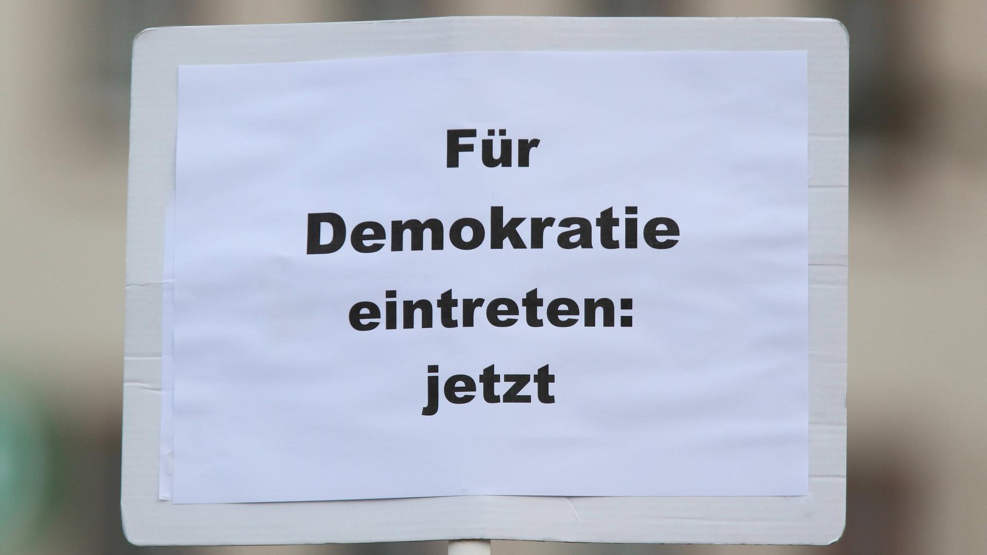 Plakat mit der Aufschrift "Für Demokratie eintreten: jetzt" bei der bundesweite Gedenkdemonstration vier Jahre nach dem rassistischen Anschlag vom 19. Februar 2020 in Hanau.