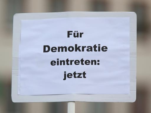 Plakat mit der Aufschrift "Für Demokratie eintreten: jetzt" bei der bundesweite Gedenkdemonstration vier Jahre nach dem rassistischen Anschlag vom 19. Februar 2020 in Hanau.