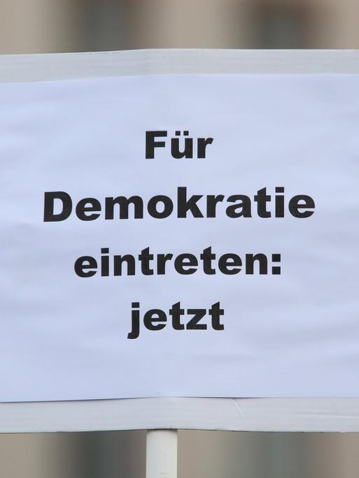 Plakat mit der Aufschrift "Für Demokratie eintreten: jetzt" bei der bundesweite Gedenkdemonstration vier Jahre nach dem rassistischen Anschlag vom 19. Februar 2020 in Hanau.