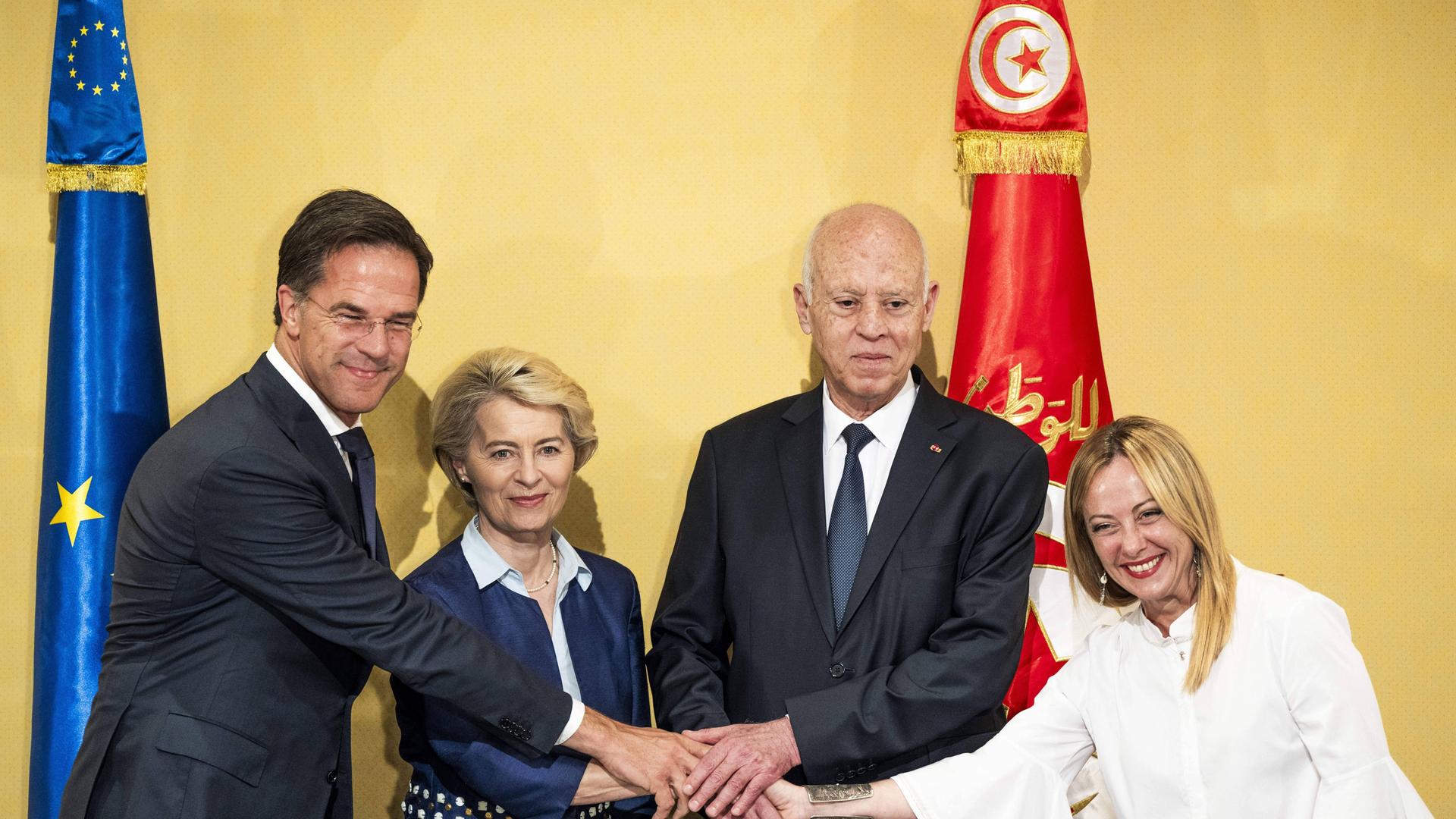 Der scheidenden niederländische Premierminister Mark Rutte, EU-Kommissionspräsidentin Ursula von der Leyen, Tunesiens Präsident Kais Saied und Italiens Premierministerin Giorgia Meloni schütteln nach Unterzeichnung des gemeinsamen Abkommens einander die Hände.