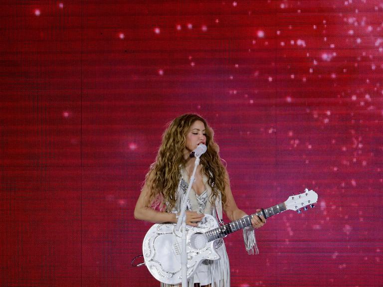 Die kolumbianische Sängerin Shakira tritt bei einem riesigen Konzert auf dem Zocalo in Mexiko-Stadt auf, sie hält eine Gitarre in der Hand. 
