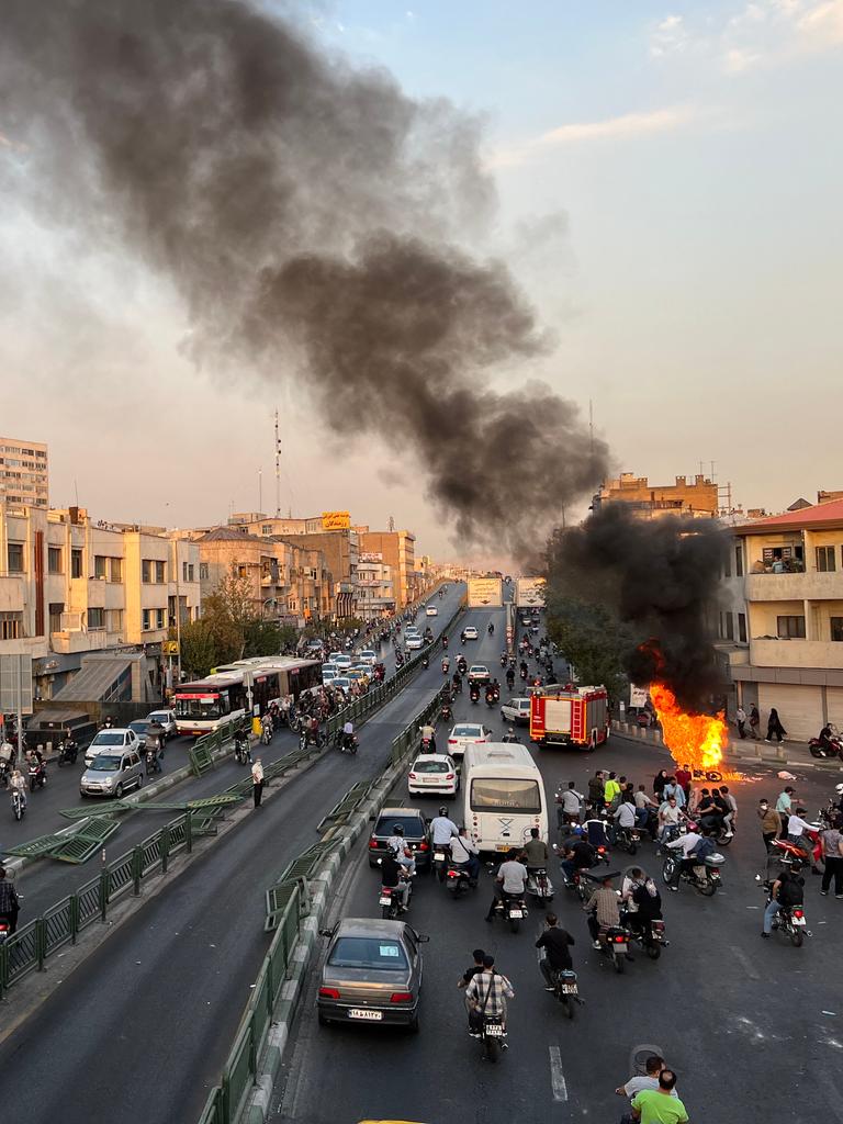 Protest im Iran: Ein Motorrad brennt in Teheran auf der Strasse, Strassenchaos drumherum. Iran, 8. Oktober 2022. 