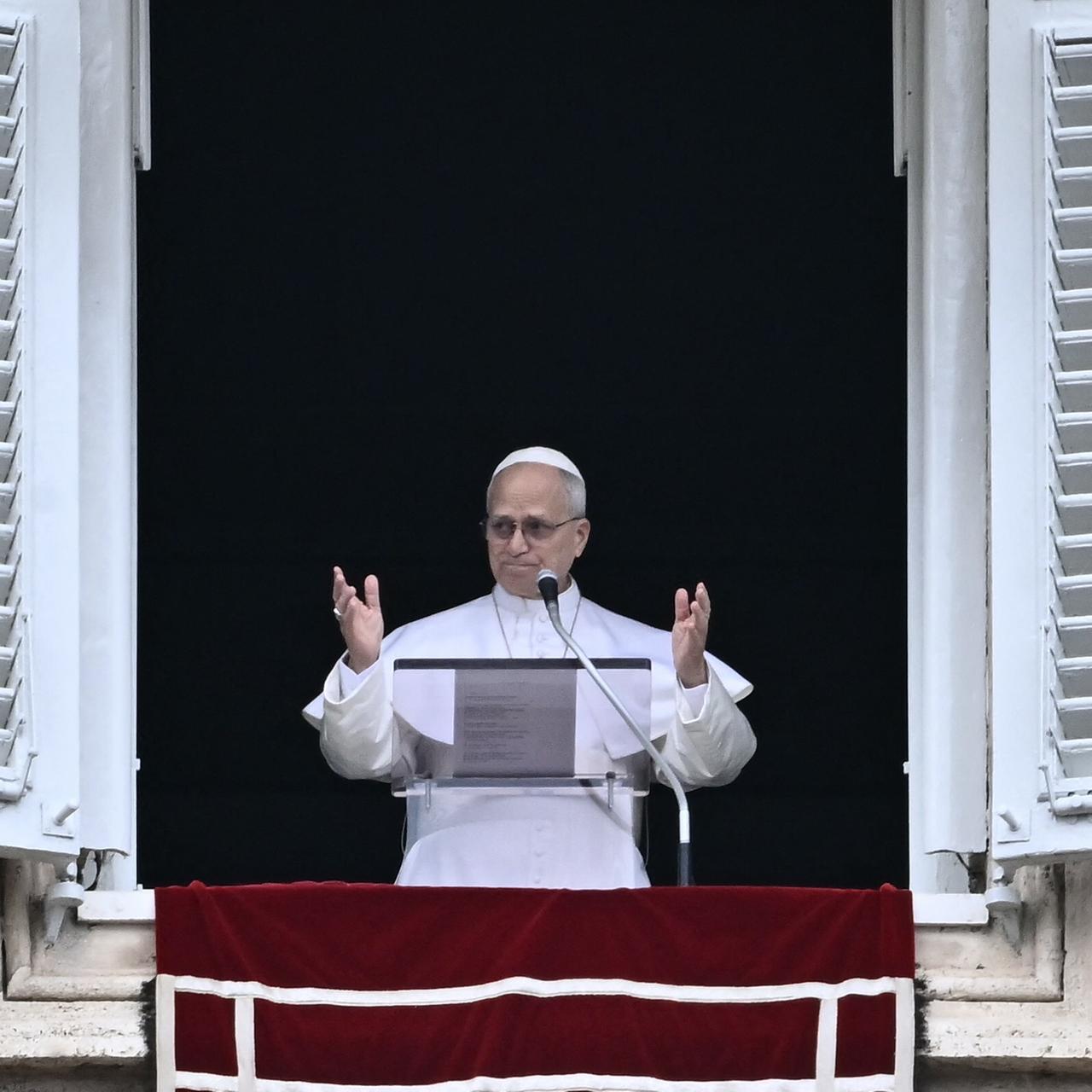Papst Leo XIV. steht am Fenster und hält eine Rede, er blickt ernst und gestikuliert