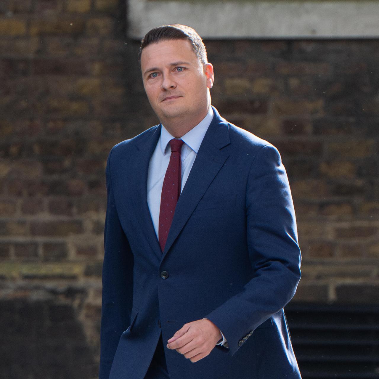 Der zurückgetretene britische Gesundheitsminister Wes Streeting läuft an einem Haus entlang; er trägt einen blauen Anzug.