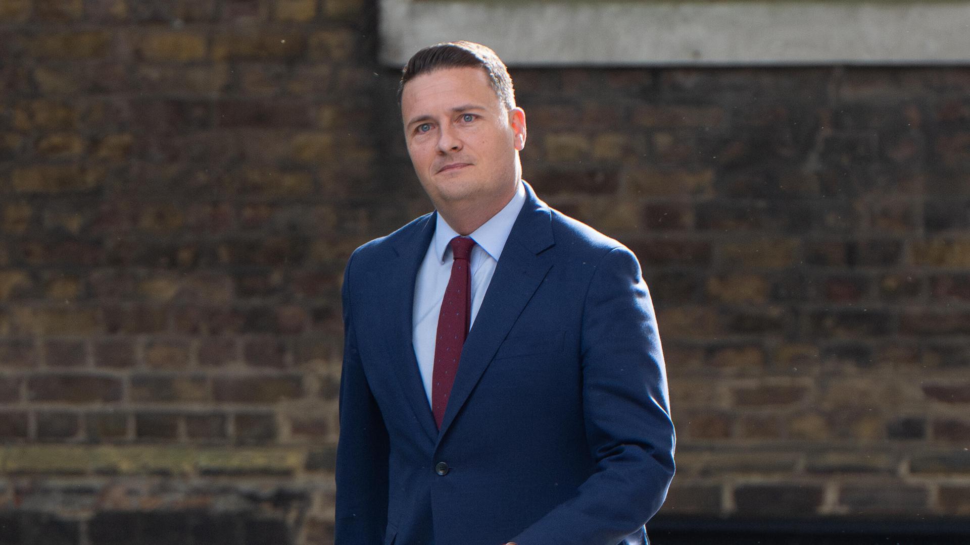 Der zurückgetretene britische Gesundheitsminister Wes Streeting läuft an einem Haus entlang; er trägt einen blauen Anzug.