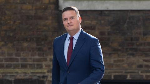 Der zurückgetretene britische Gesundheitsminister Wes Streeting läuft an einem Haus entlang; er trägt einen blauen Anzug.