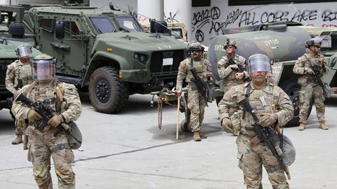 Soldaten der US-amerikanischen Nationalgarde stehen in voller Montur vor ihren Fahrzeugen. 