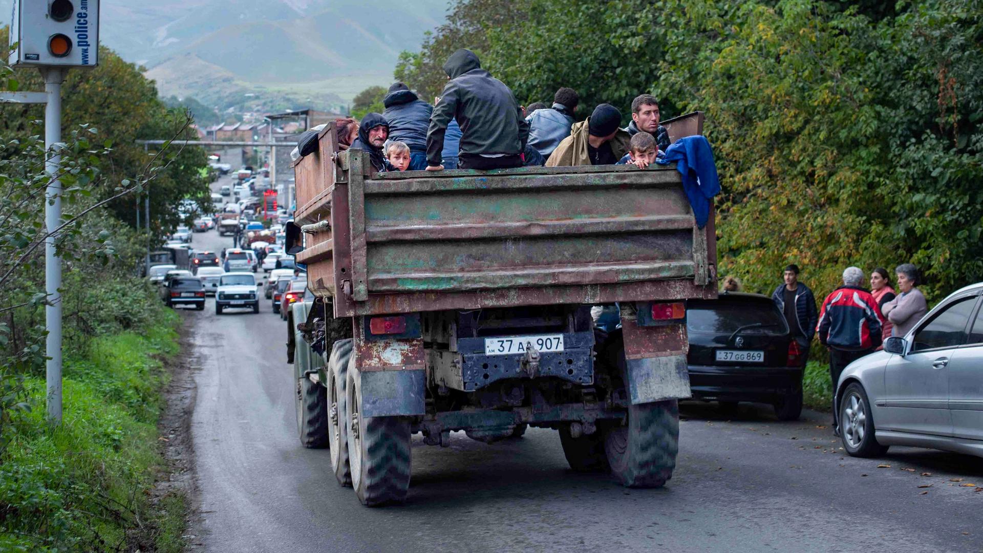 Armenien, Goris: Ethnische Armenier aus Berg-Karabach sitzen in einem Lastwagen auf dem Weg nach Goris in der Region Syunik.