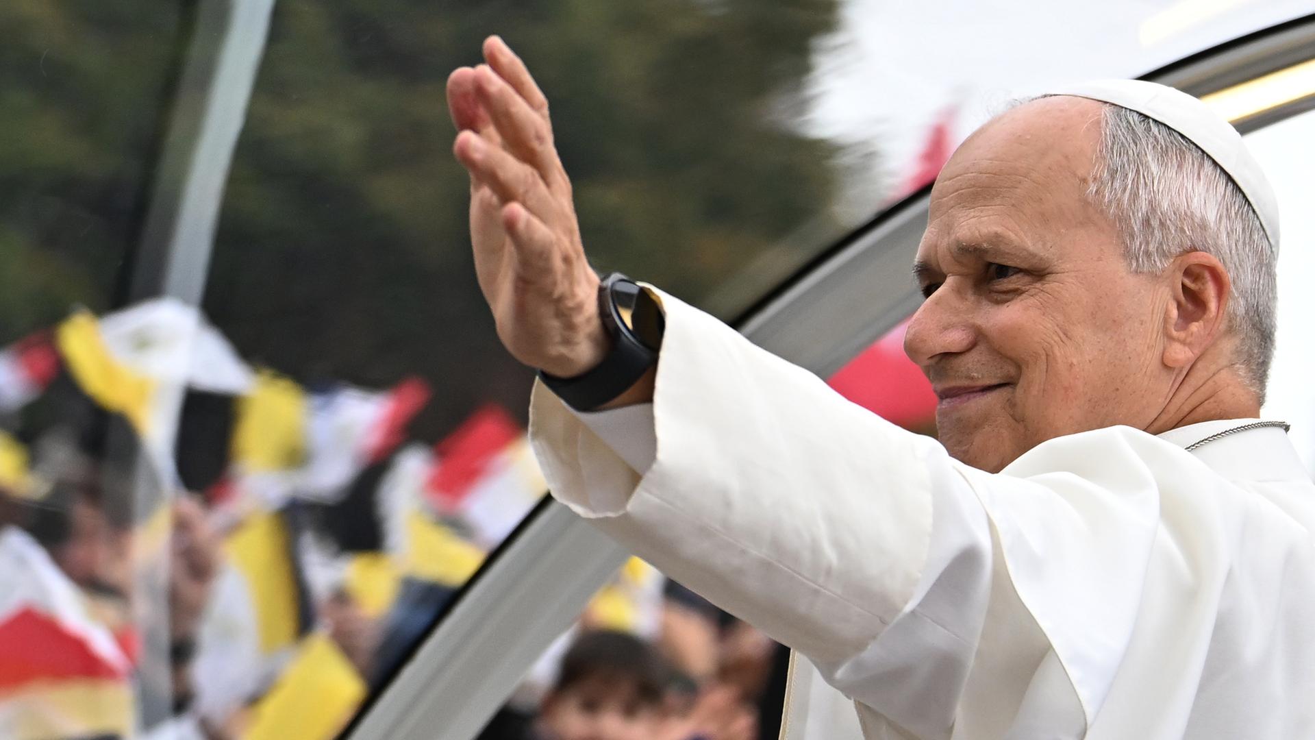 Der Papst winkt einer Menschenmenge in Paris zu. Der Papst winkt einer Menschenmenge in Paris zu.