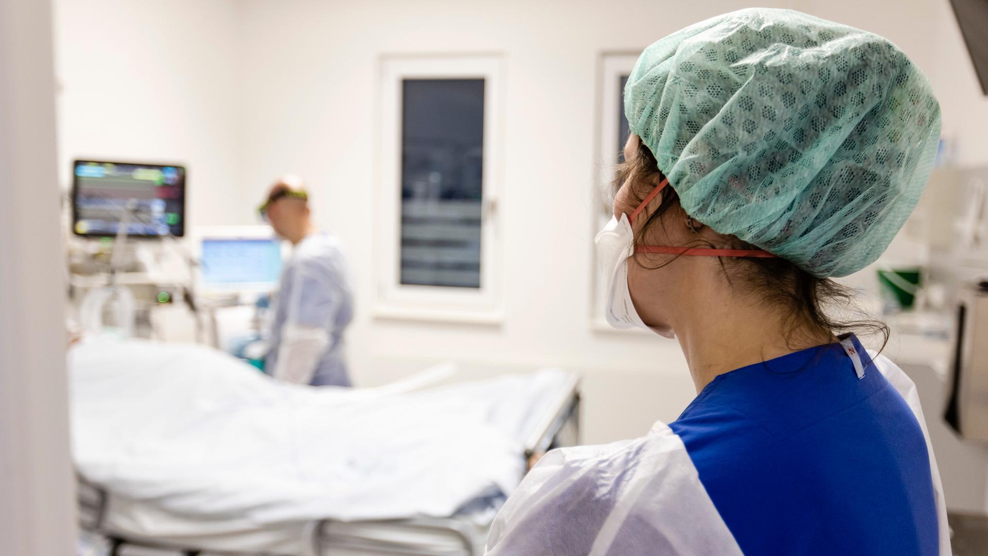 Ein Fachkrankenpfleger und eine Ãrztin  schauen nach einer Patientin auf der Intensivstation am Universitätsklinikum Schleswig-Holstein.