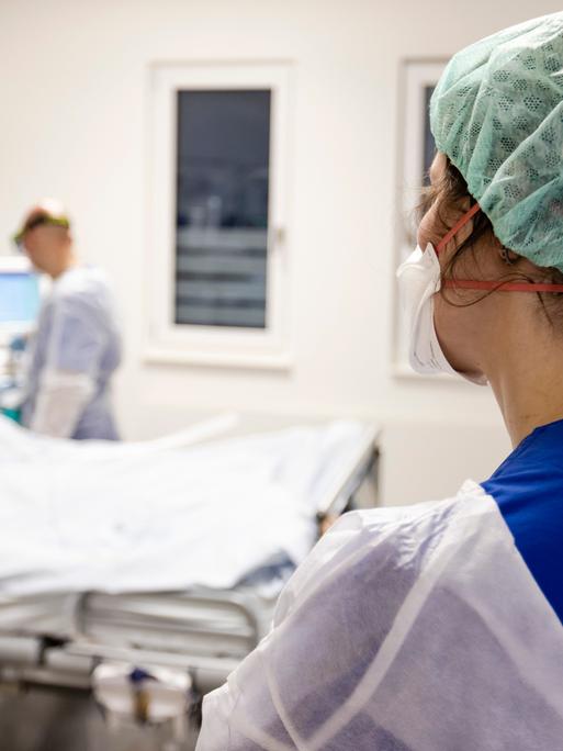 Ein Fachkrankenpfleger und eine Ãrztin  schauen nach einer Patientin auf der Intensivstation am Universitätsklinikum Schleswig-Holstein.