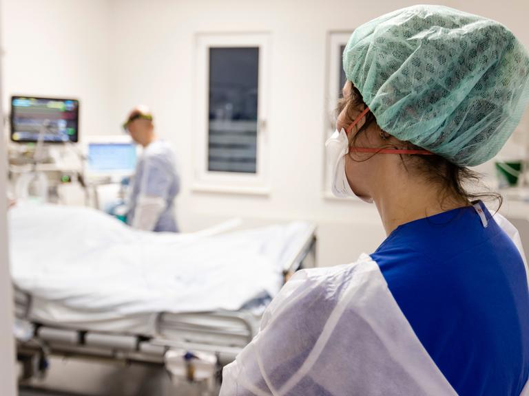 Ein Fachkrankenpfleger und eine Ãrztin  schauen nach einer Patientin auf der Intensivstation am Universitätsklinikum Schleswig-Holstein.